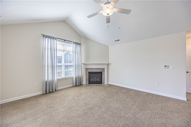 unfurnished living room with lofted ceiling, a fireplace, ceiling fan, and light colored carpet