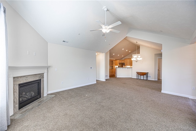 unfurnished living room with carpet floors, ceiling fan with notable chandelier, a high end fireplace, and lofted ceiling