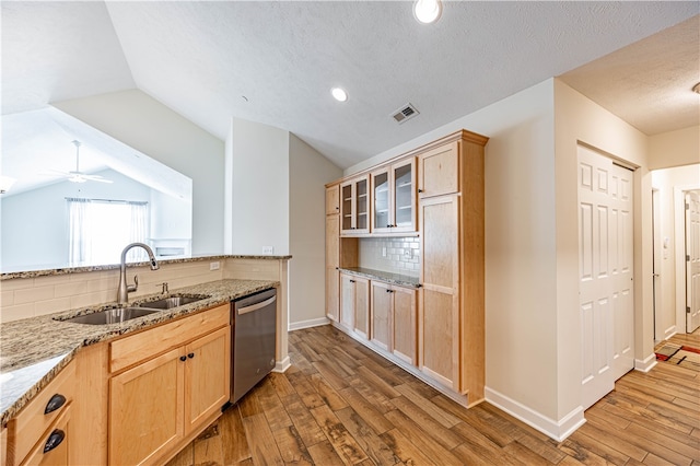 kitchen featuring light hardwood / wood-style floors, stainless steel dishwasher, lofted ceiling, and sink