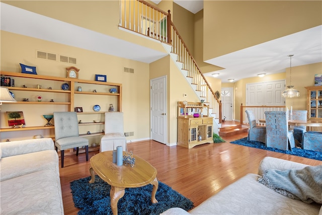 living room with a towering ceiling and hardwood / wood-style flooring