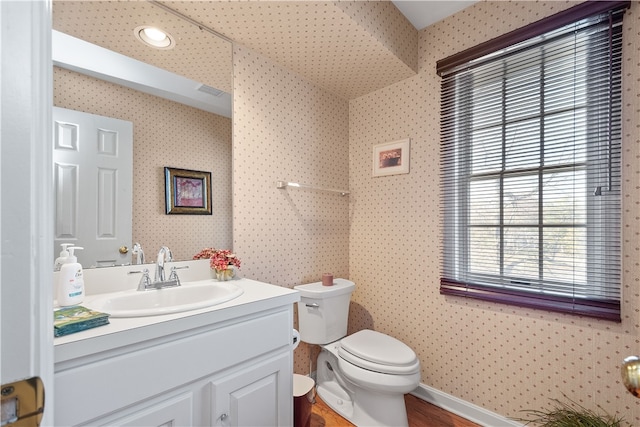 bathroom featuring toilet, hardwood / wood-style flooring, and vanity