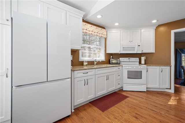 kitchen with white cabinetry, light stone countertops, light wood-type flooring, sink, and white appliances