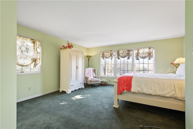 bedroom with dark carpet and multiple windows