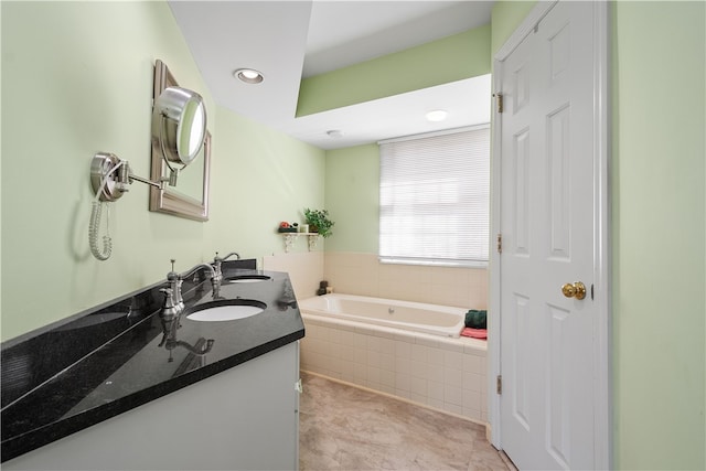 bathroom with vanity and tiled tub