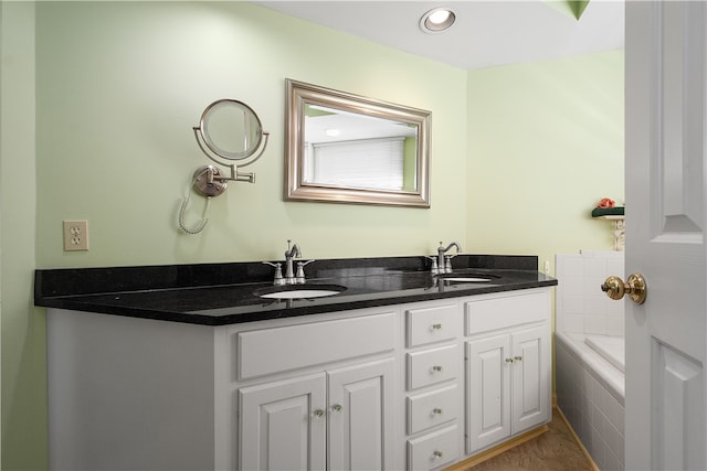 bathroom featuring vanity and a relaxing tiled tub