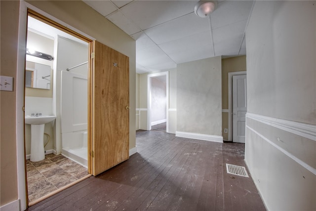 interior space with sink, a paneled ceiling, and dark hardwood / wood-style flooring