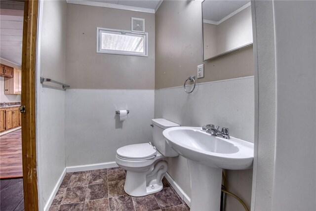 bathroom featuring ornamental molding and toilet