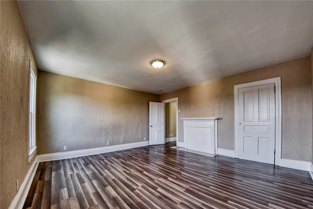 interior space with a textured ceiling and dark wood-type flooring