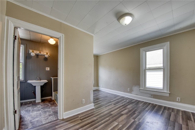 spare room featuring wood walls, ornamental molding, and dark hardwood / wood-style floors