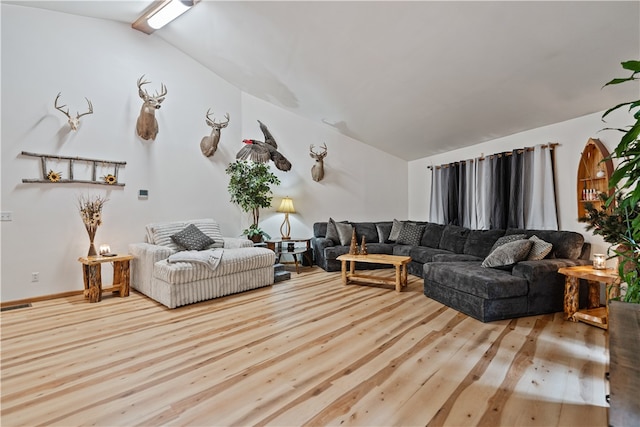 living room featuring light wood-type flooring and vaulted ceiling