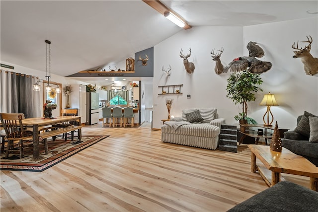 living room featuring vaulted ceiling, a chandelier, and hardwood / wood-style floors