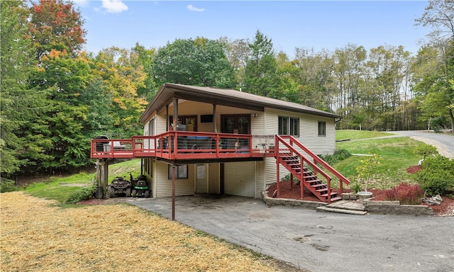 view of front facade with a carport, a front lawn, and a wooden deck