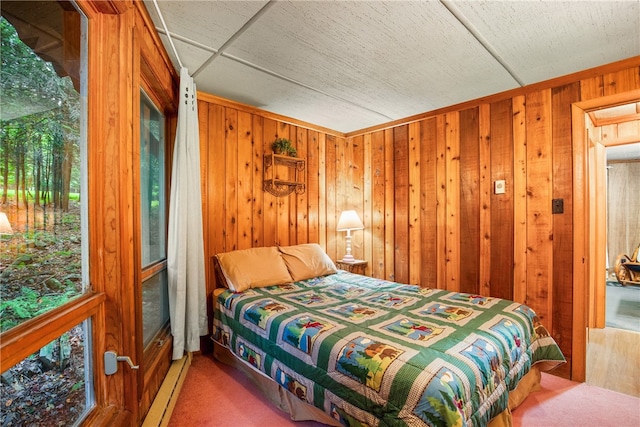 carpeted bedroom featuring wooden walls and a baseboard heating unit