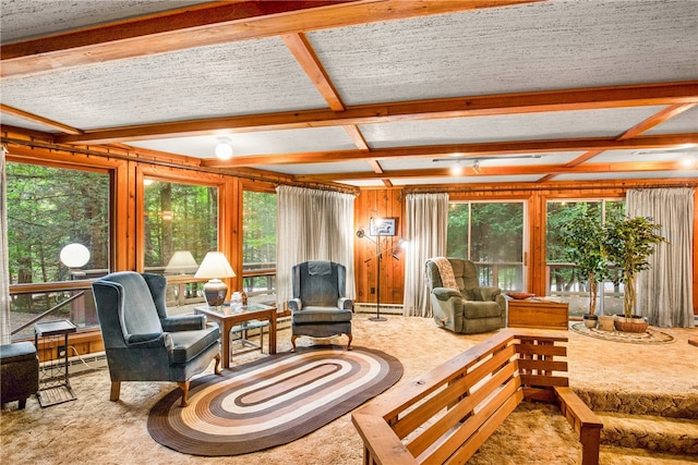 living room featuring a textured ceiling, wood walls, beamed ceiling, and a baseboard radiator