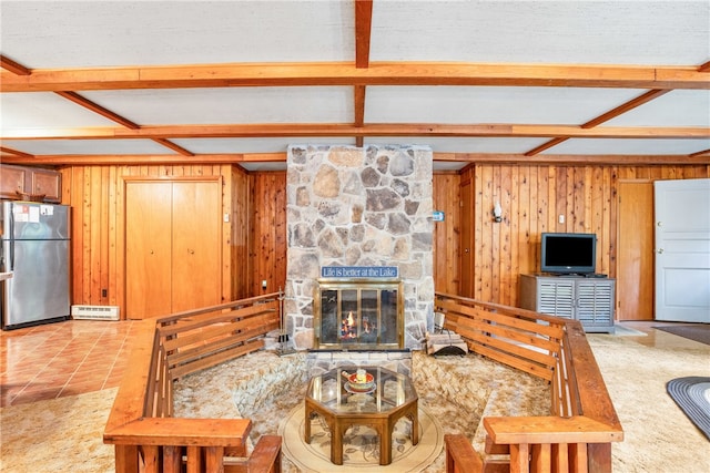 tiled living room with wooden walls, a textured ceiling, beamed ceiling, and a fireplace