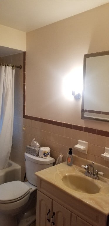 full bathroom featuring tile walls, shower / tub combo with curtain, vanity, and toilet