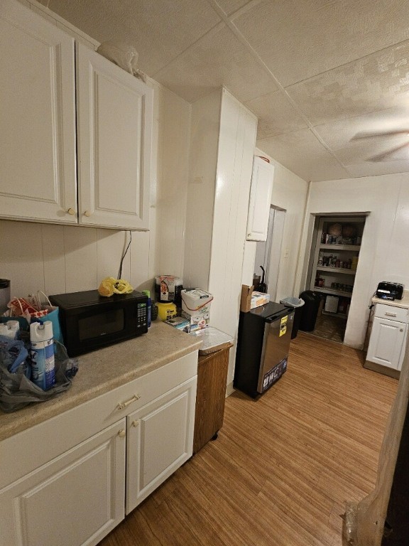 kitchen with white cabinets and light wood-type flooring