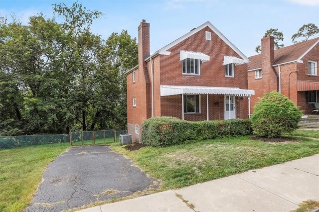 view of front of home with central air condition unit and a front yard