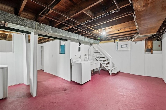 basement with washer and clothes dryer, carpet flooring, sink, and electric panel