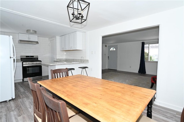 dining area featuring an inviting chandelier and light wood-type flooring