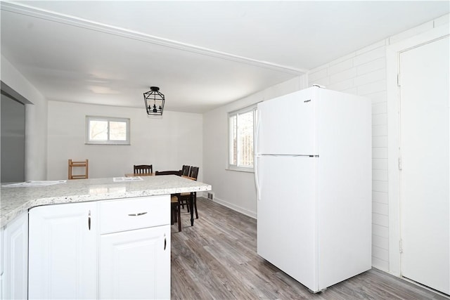 kitchen with white cabinetry, light hardwood / wood-style flooring, and white refrigerator