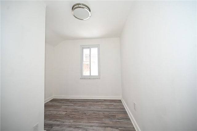 unfurnished room featuring dark hardwood / wood-style flooring and vaulted ceiling