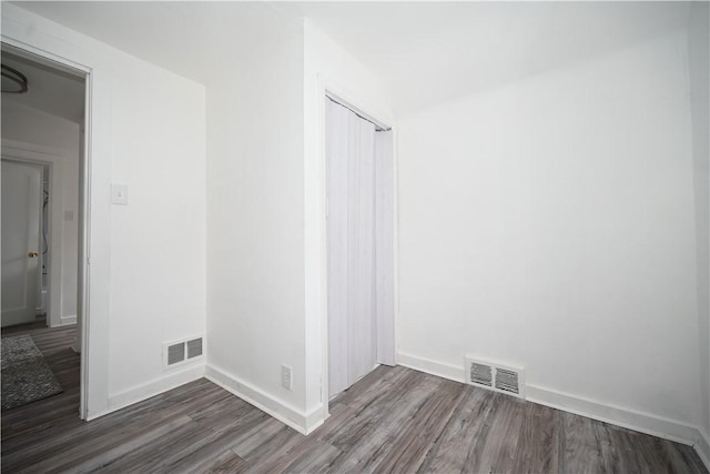 spare room featuring dark wood-type flooring