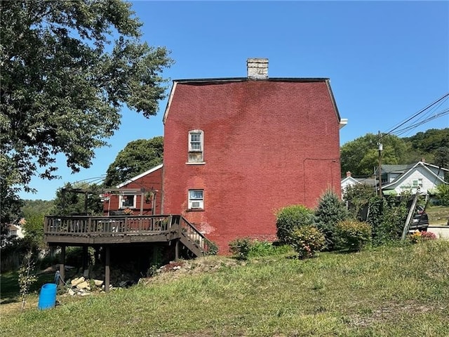 rear view of house featuring a deck and a yard