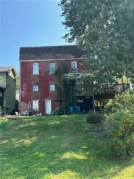 back of house featuring a lawn