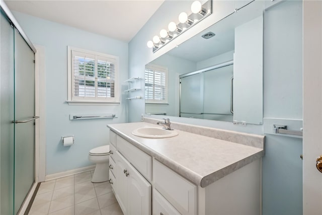 bathroom with toilet, vanity, tile patterned floors, and a shower with door