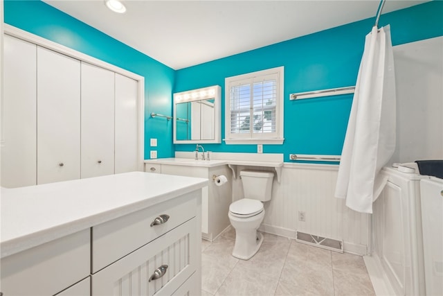 bathroom featuring toilet, vanity, and tile patterned floors