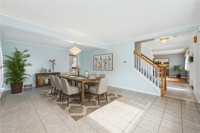 tiled dining room with a chandelier and crown molding