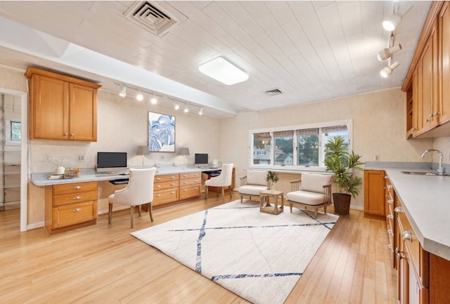 office space featuring track lighting, sink, wooden ceiling, light wood-type flooring, and built in desk