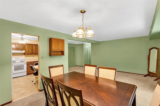 carpeted dining area with ceiling fan with notable chandelier