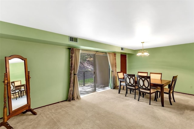 carpeted dining room featuring an inviting chandelier