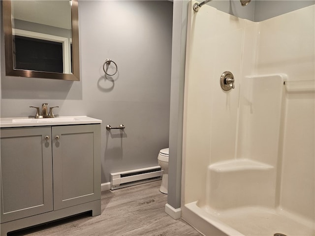 101 Main, St, PA 16050 - bathroom featuring vanity, hardwood / wood-style floors, a baseboard heating unit, walk in shower, and toilet