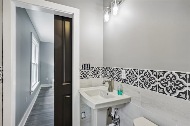 bathroom featuring tile walls, hardwood / wood-style floors, and toilet