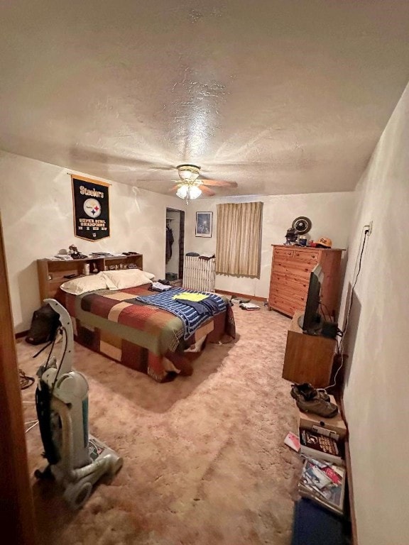 bedroom featuring carpet floors, a textured ceiling, and ceiling fan