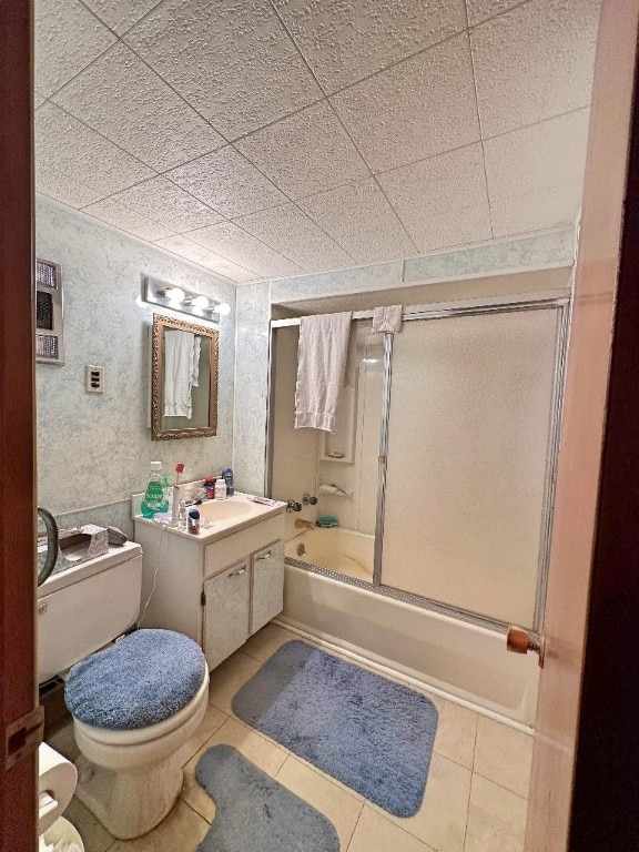 full bathroom with shower / bath combination with glass door, vanity, tile patterned flooring, and toilet