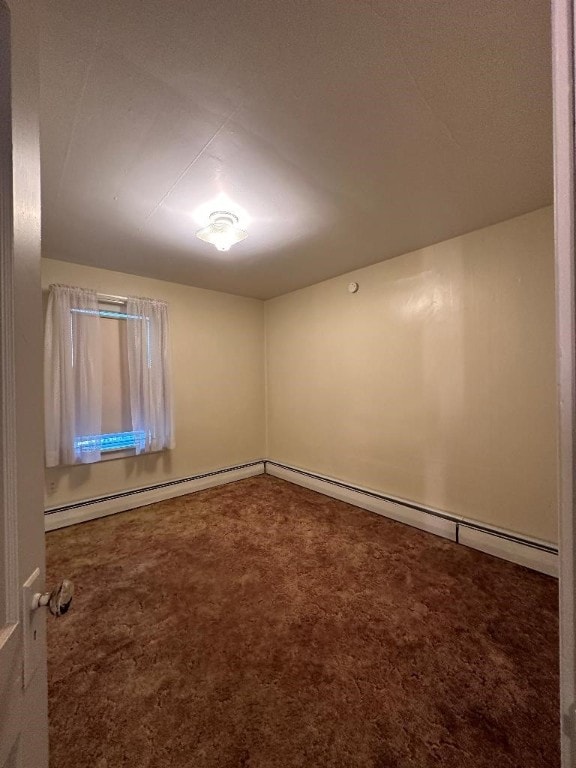 spare room featuring baseboard heating and carpet flooring