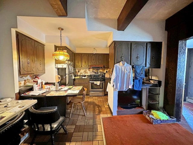 kitchen featuring appliances with stainless steel finishes, pendant lighting, beam ceiling, range hood, and sink