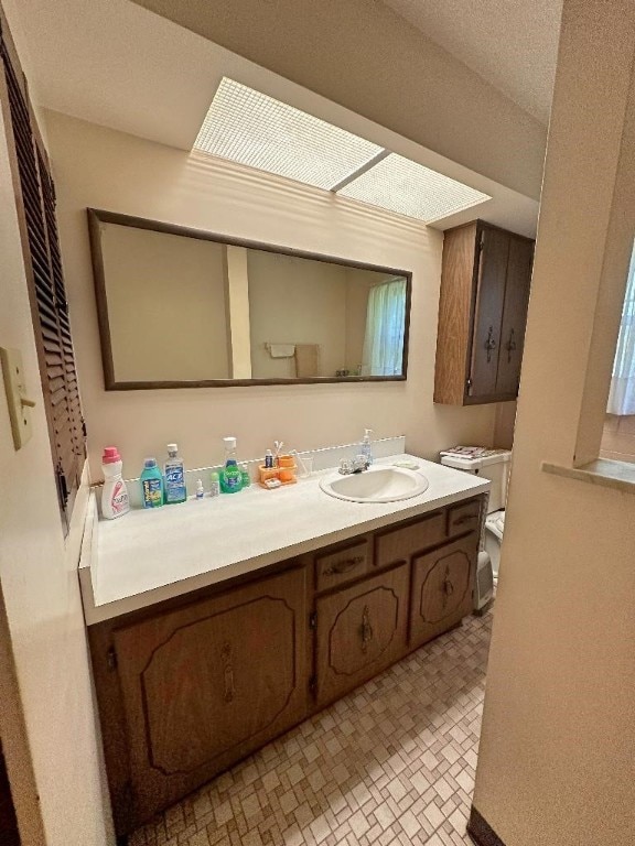 bathroom featuring vanity, toilet, and a textured ceiling