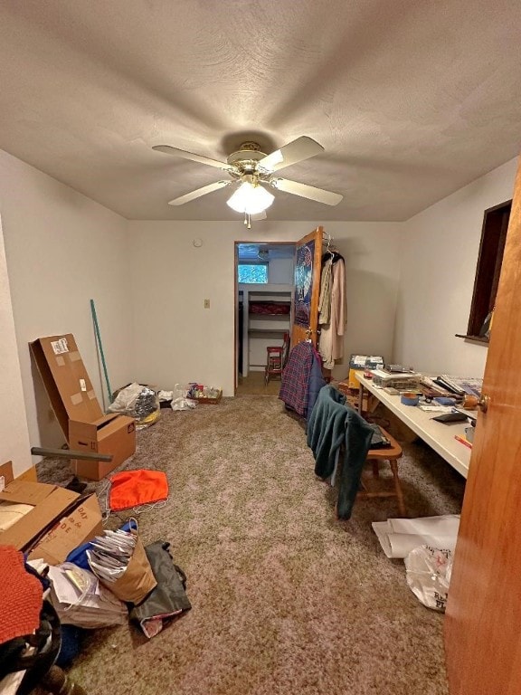 home office with ceiling fan, a textured ceiling, and carpet