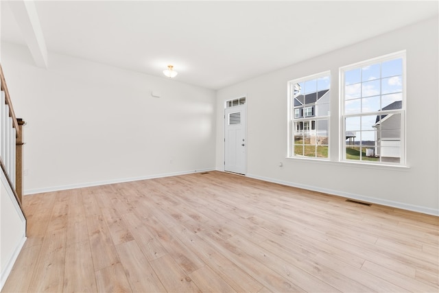 foyer featuring beam ceiling and light hardwood / wood-style flooring