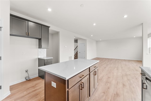 kitchen featuring a kitchen island, light wood-type flooring, and backsplash