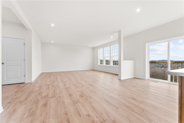 unfurnished living room with light wood-type flooring and plenty of natural light