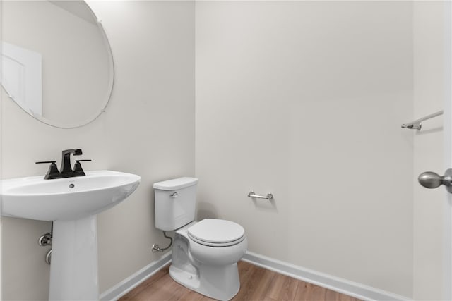 bathroom featuring hardwood / wood-style flooring and toilet