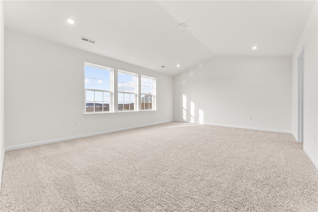 carpeted empty room featuring lofted ceiling