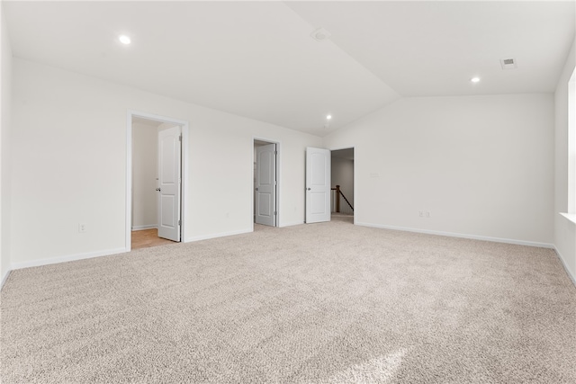 unfurnished bedroom with light colored carpet and vaulted ceiling