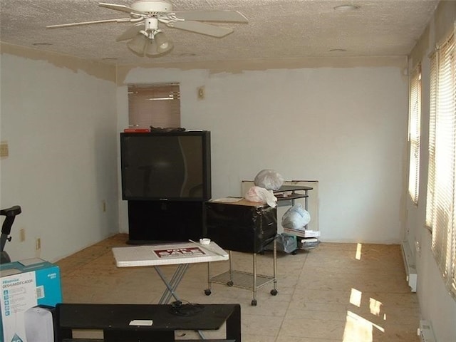 living room featuring ceiling fan and a textured ceiling